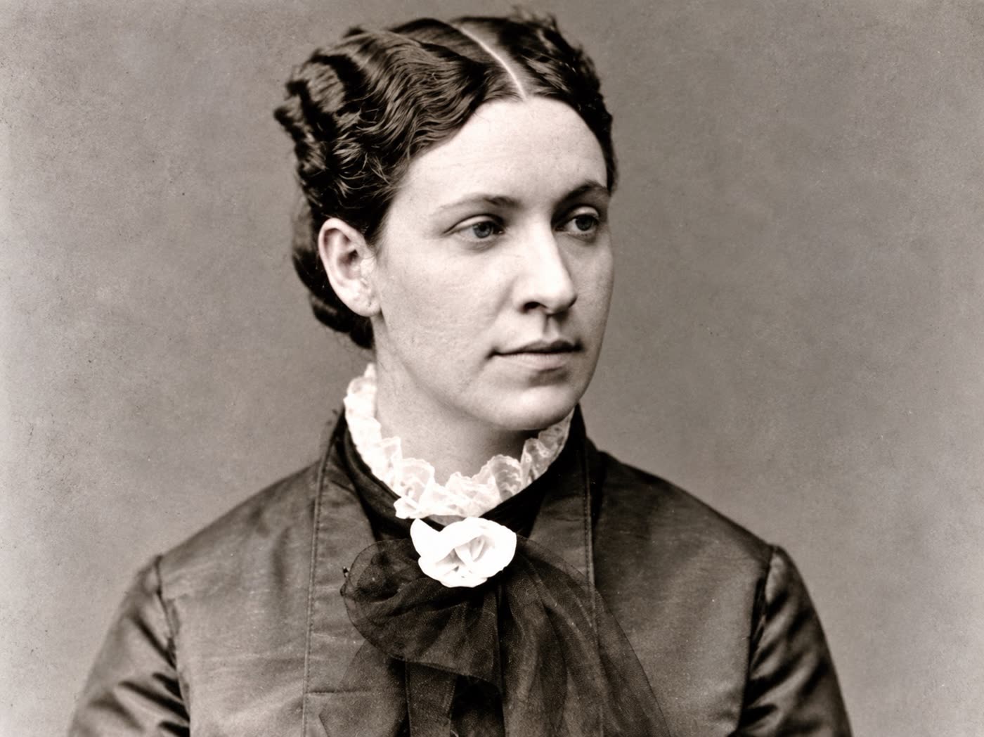 A nineteenth-century studio portrait of a young woman in a dark dress with a lace collar